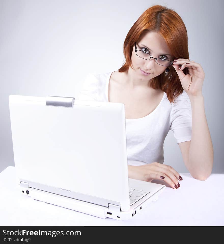 Red-haired girl with white notebook.