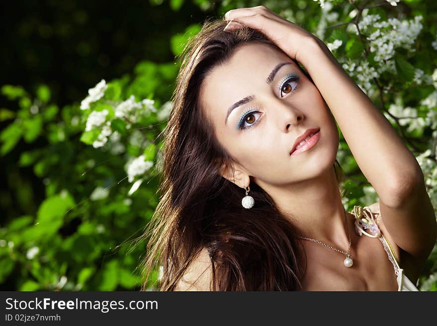 The attractive young girl in greens of trees. The attractive young girl in greens of trees