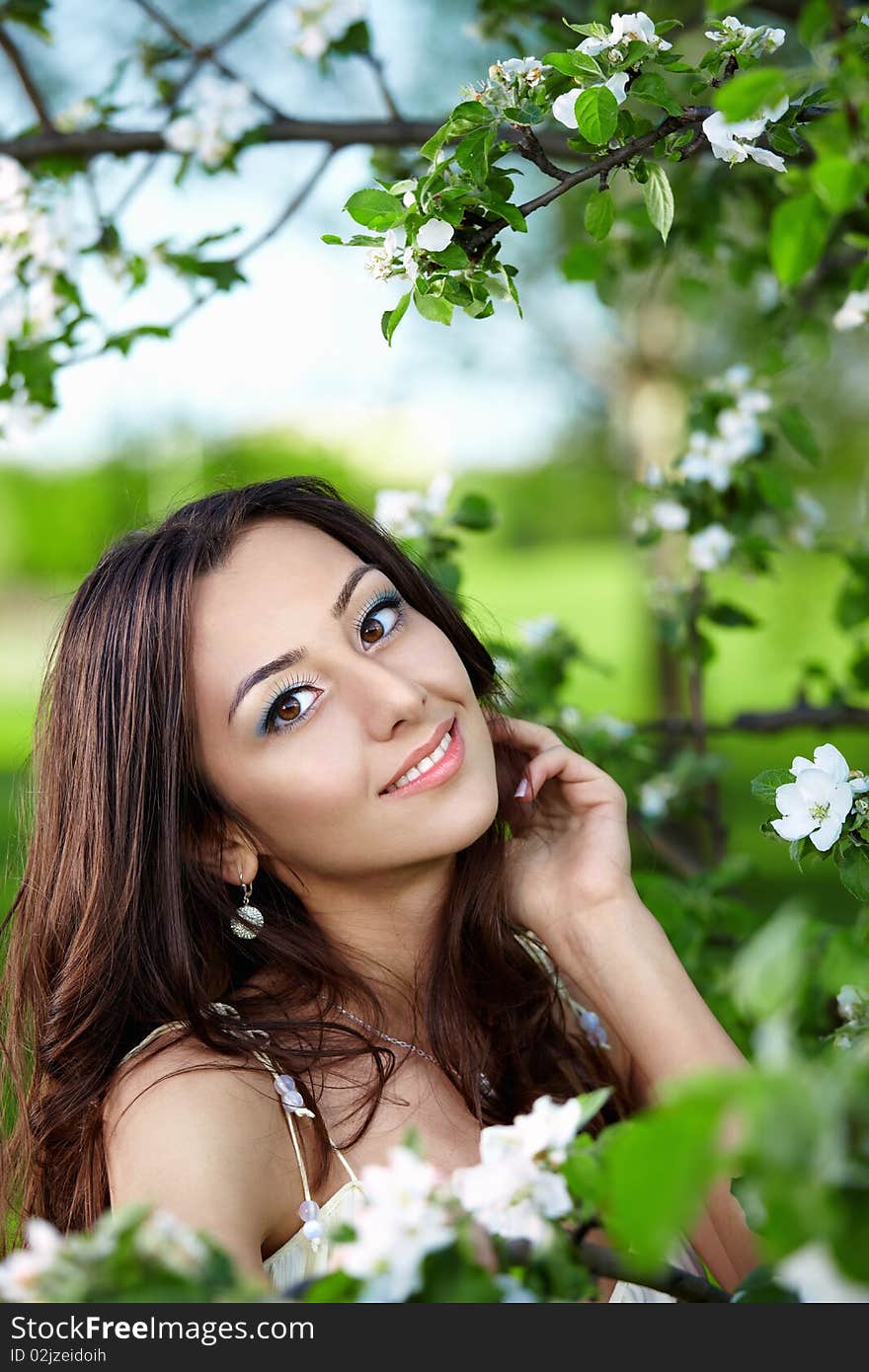 The nice girl against a green tree with colours. The nice girl against a green tree with colours