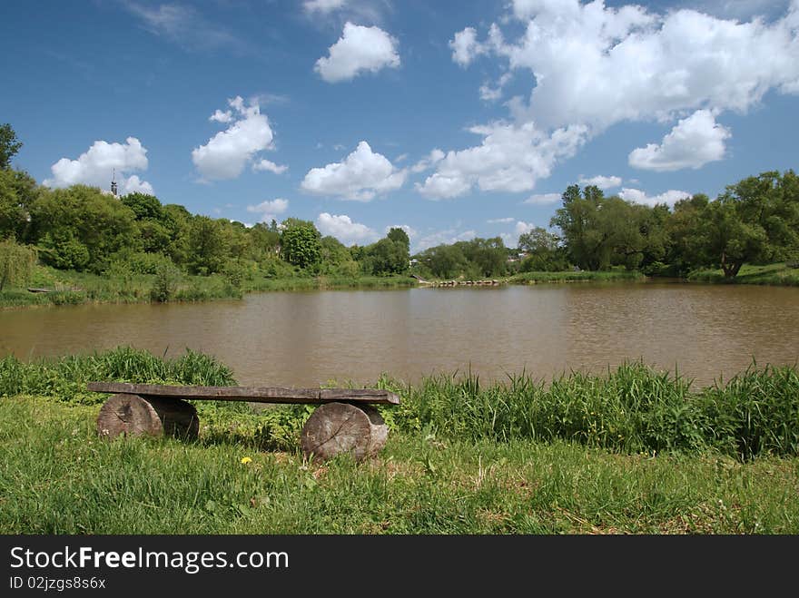 Rural view with bench and cloudy sky. Rural view with bench and cloudy sky