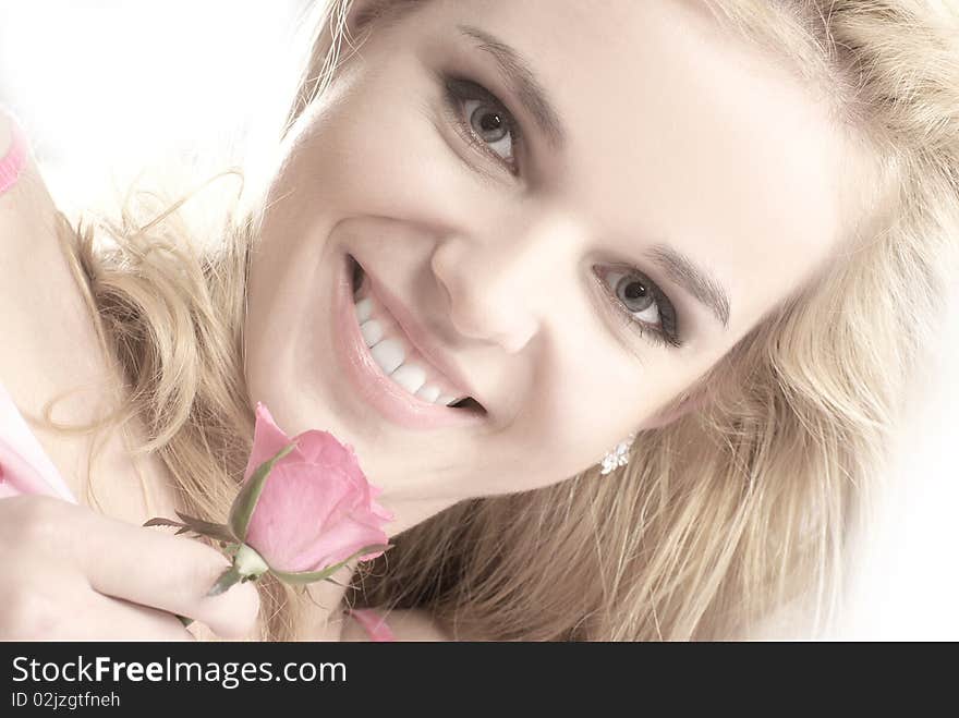 Portrait of a young blond holding a pink rose