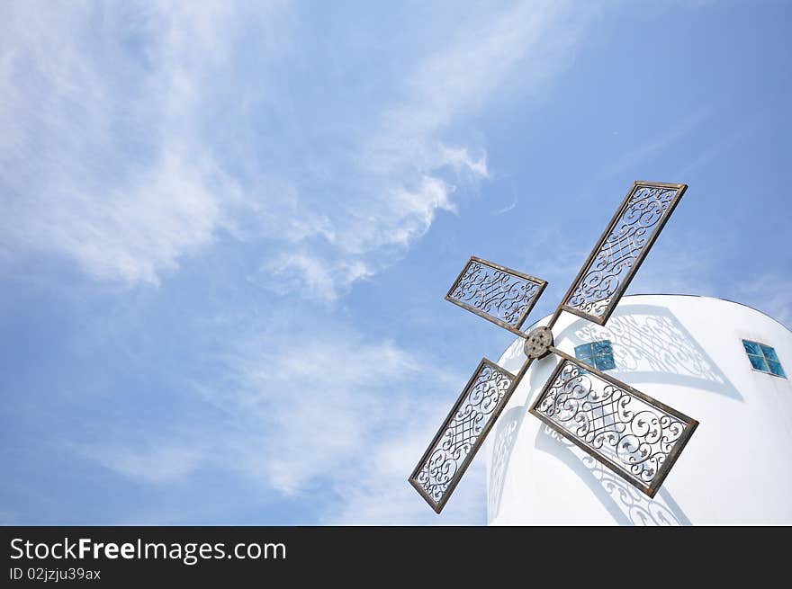 It is a white windmill on a cloudy sky