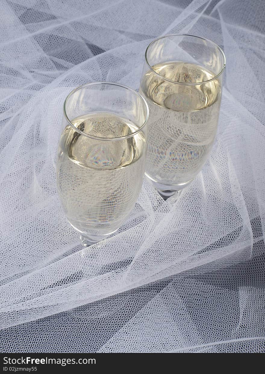 Glasses with champagne and white veil