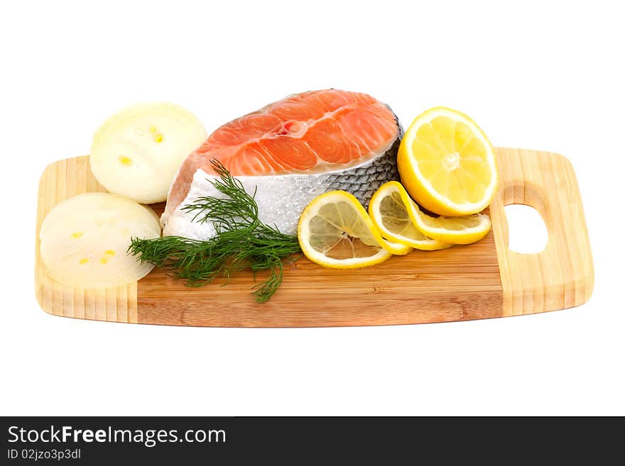 Salmon steak, lemon and onions on a cutting board isolated on white