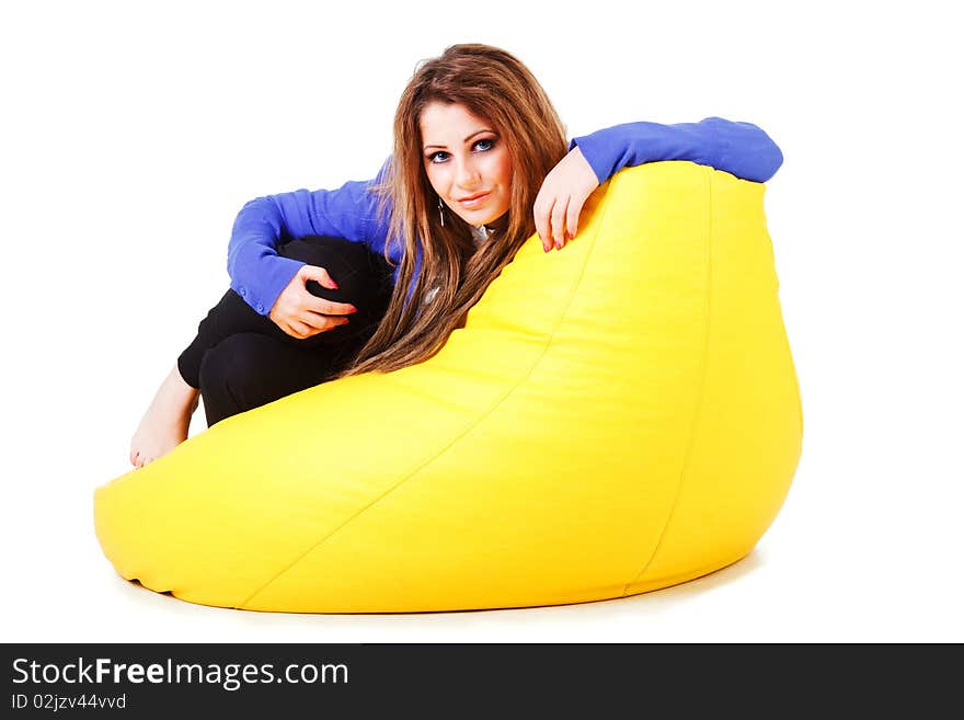 Picture of a charming young girl in blue on armchair. White background. Picture of a charming young girl in blue on armchair. White background.