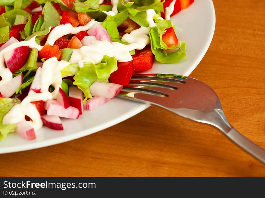 Depicted in white salad bowl, fork, close-up