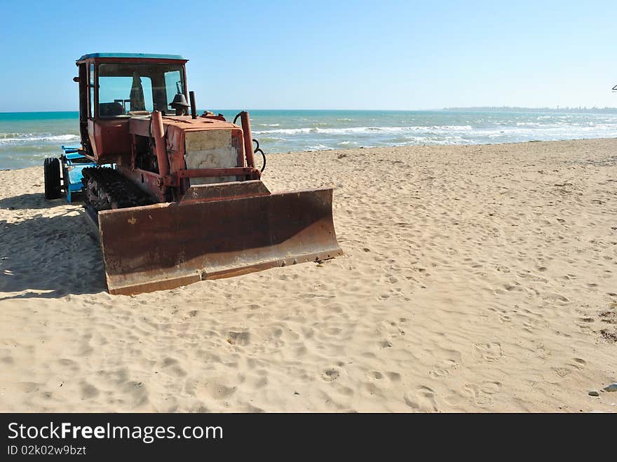 Bulldozer on the beach and surf