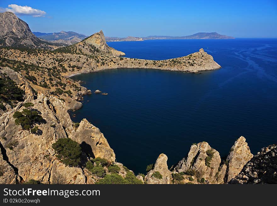 Mountain and sea landscape east of crimea. The mountains and rocks, covered with juniper and pine. Blue sea. Mountain and sea landscape east of crimea. The mountains and rocks, covered with juniper and pine. Blue sea