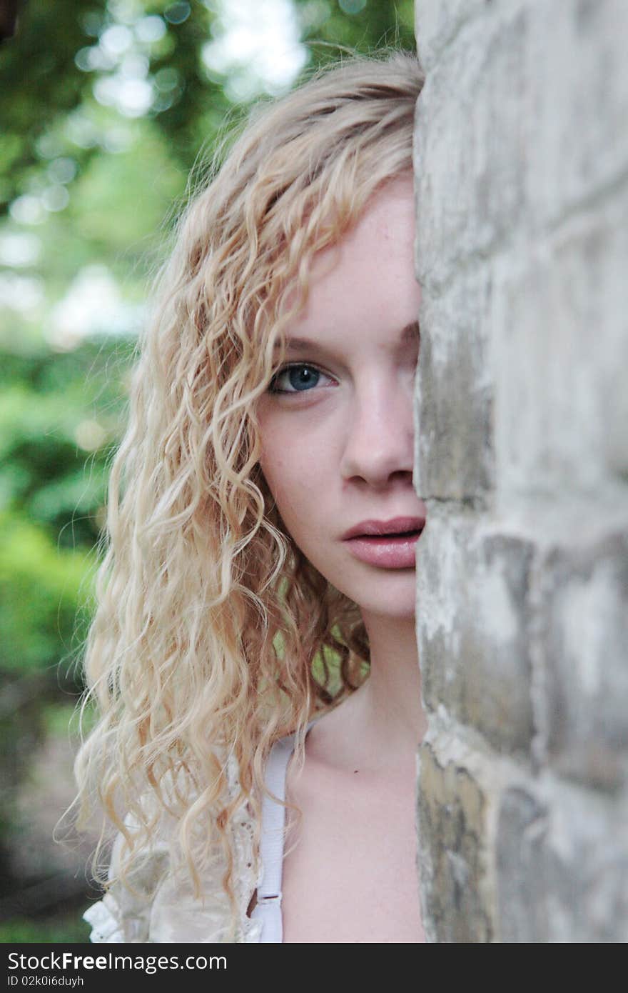 Girl looks frightened out of the wall