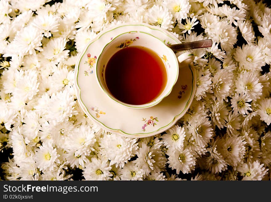 Cup of tea in flowers surrounding