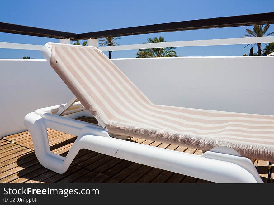 View of a deckchair with a blue sky background. View of a deckchair with a blue sky background