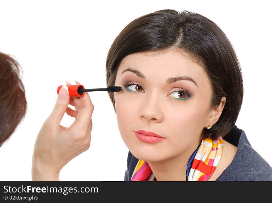 Young brown eyed lady applying mascara using lash brush