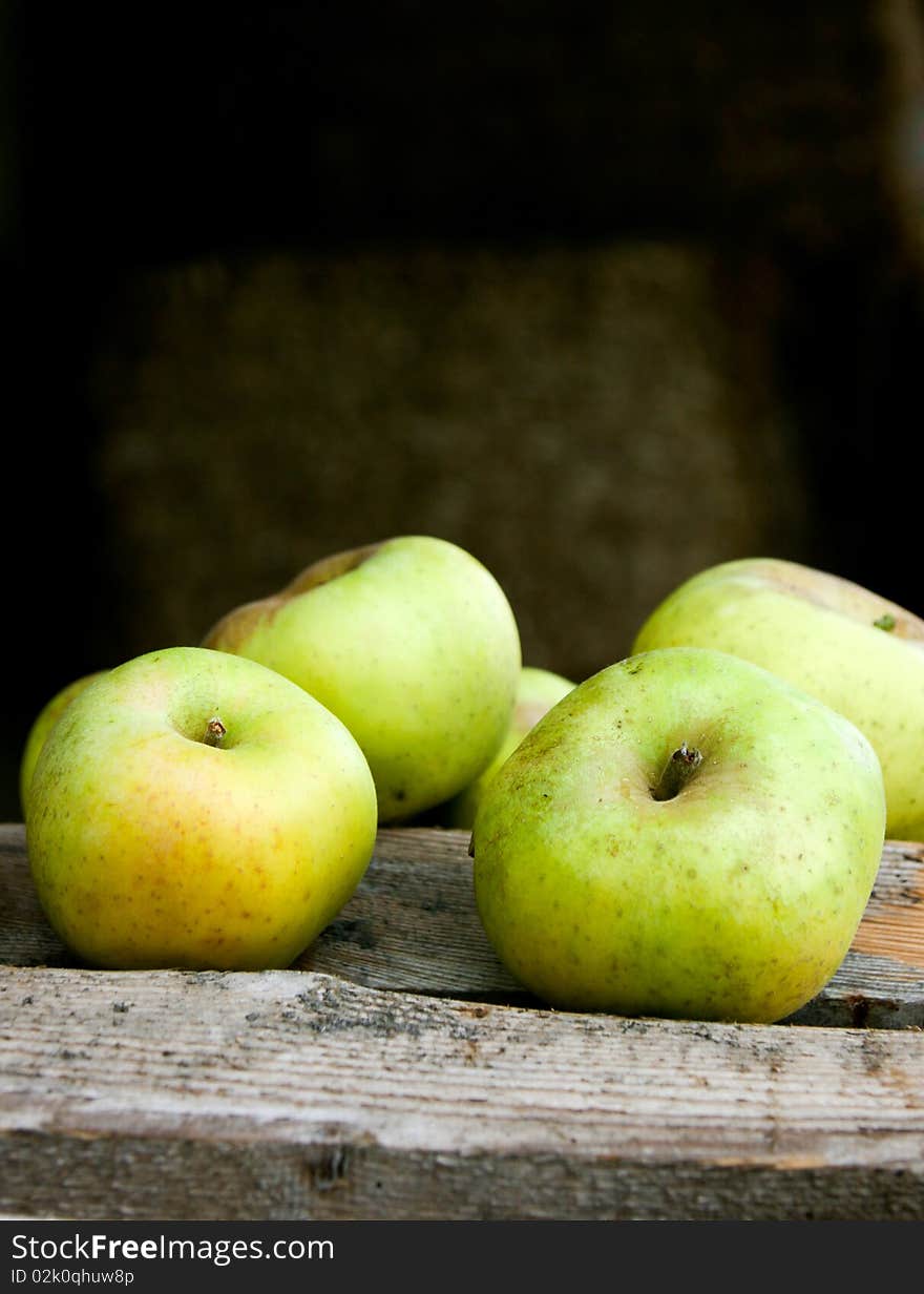 An image of juicy green apples on wooden bars