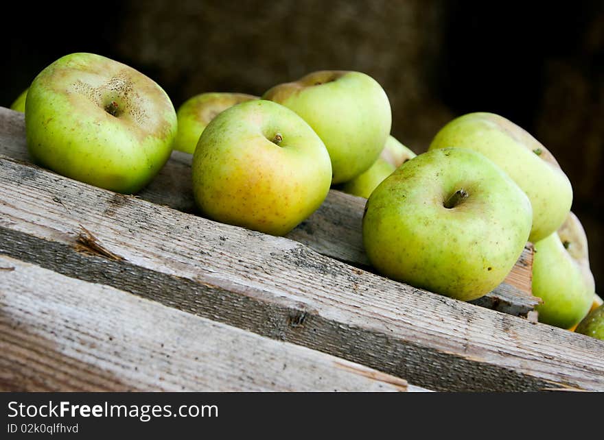 An image of juicy green apples on wooden bars