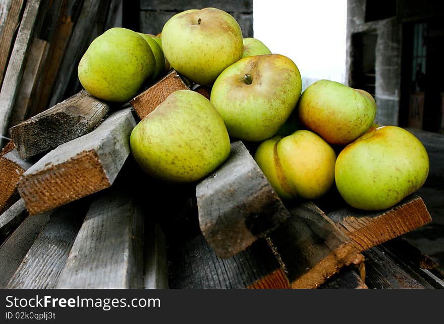 An image of green apples on wooden bars. An image of green apples on wooden bars