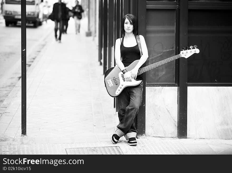 Young beautiful female guitarist in black and white. Young beautiful female guitarist in black and white