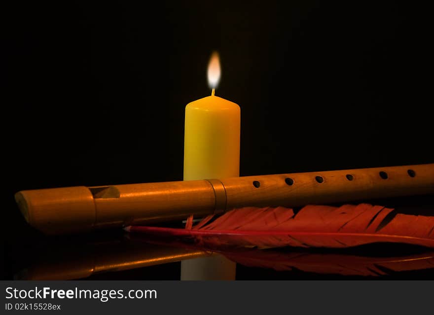 Still Life with flute, burning candle and red feather. Still Life with flute, burning candle and red feather