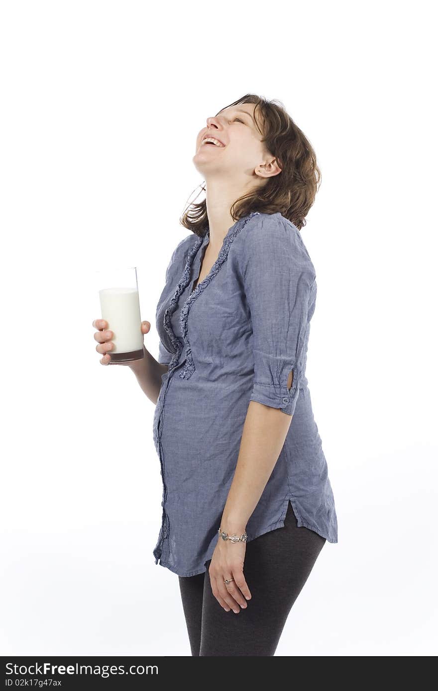 Pregnant woman with glass of milk laughing and enjoying