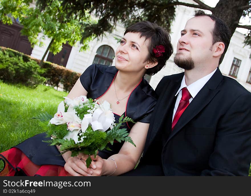 Happy young couple standing below tree