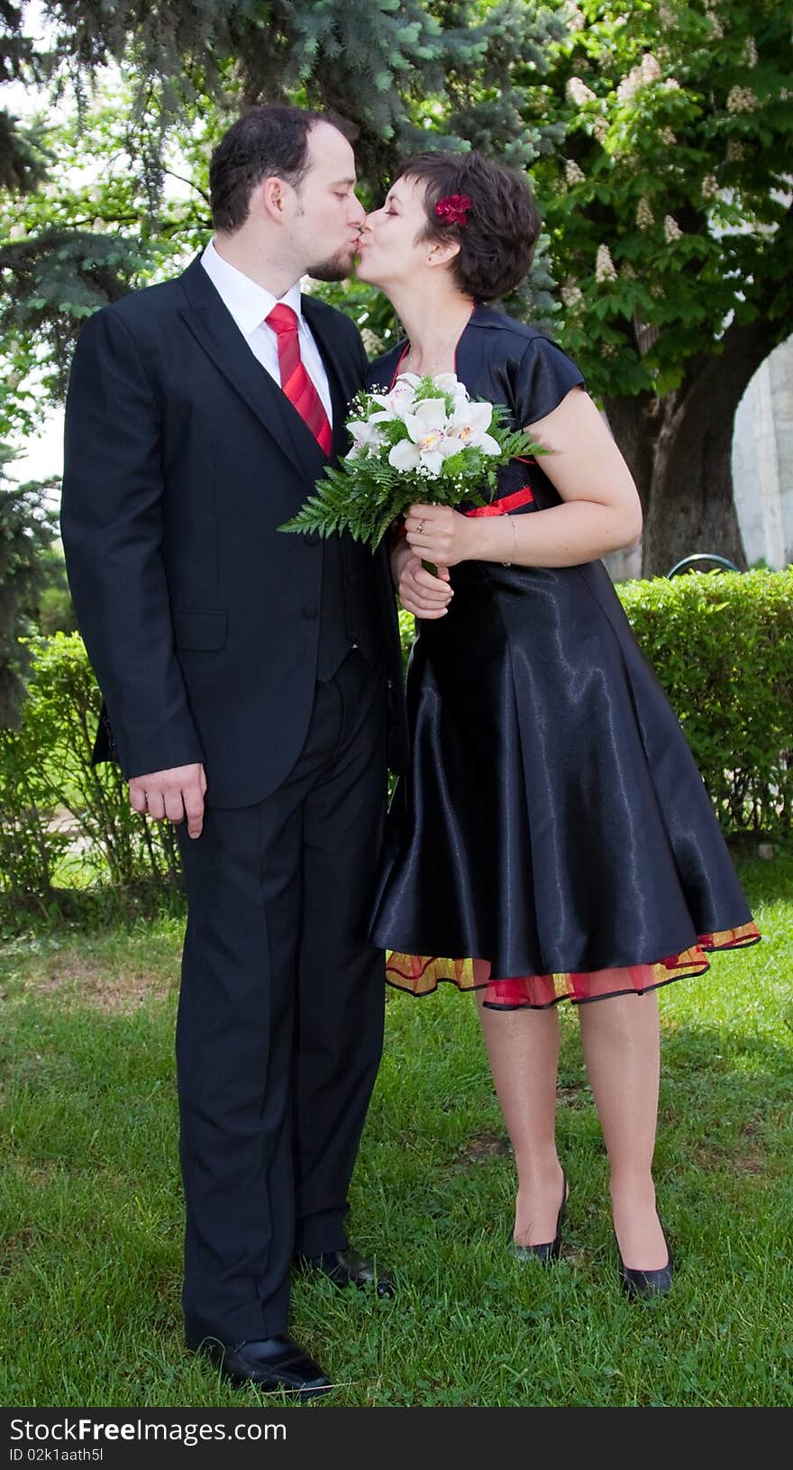 Happy young couple kissing - woman with bouquet