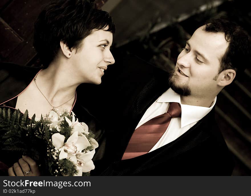 Happy young couple looking at eachother - woman with bouquet