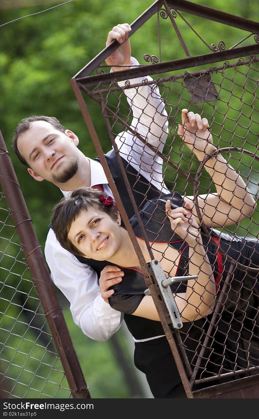 Happy young couple posing - looking from behind door