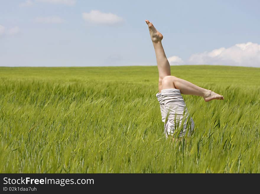 Female legs raised up from green grass