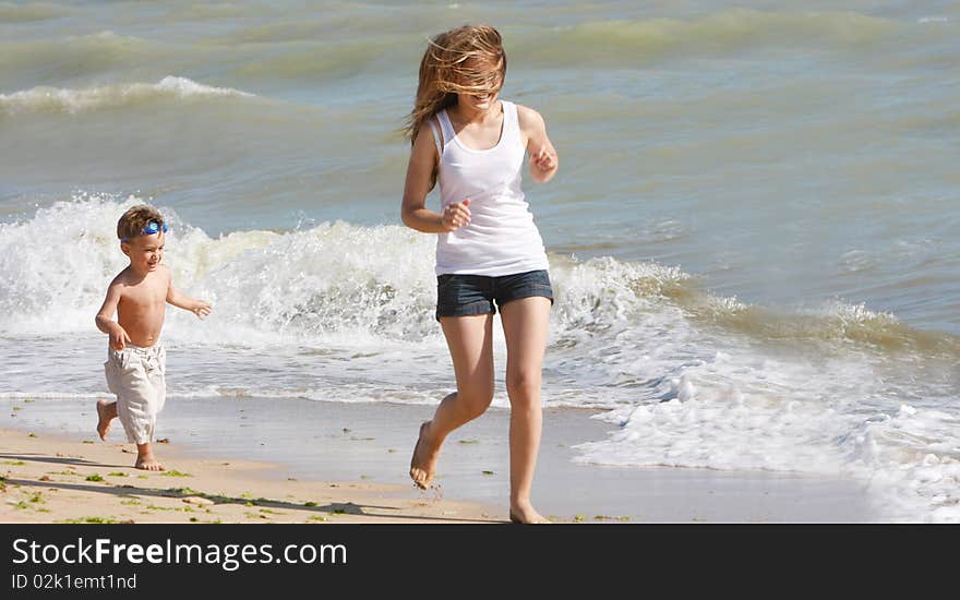 Happy mother and son running on beach