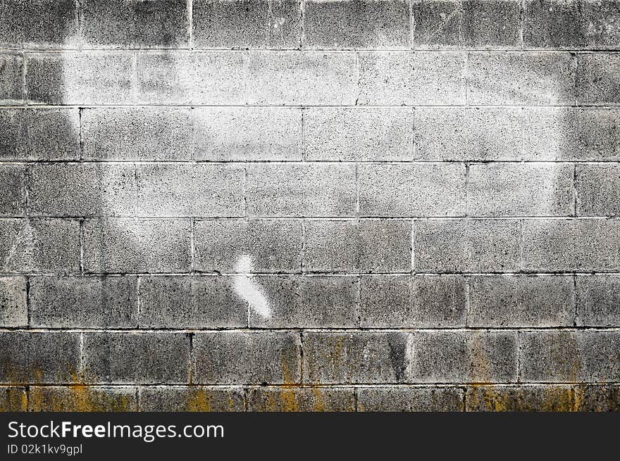 Worn out textured cement gray wall with some white spray paint on it and yellow decay on the bottom. Worn out textured cement gray wall with some white spray paint on it and yellow decay on the bottom.