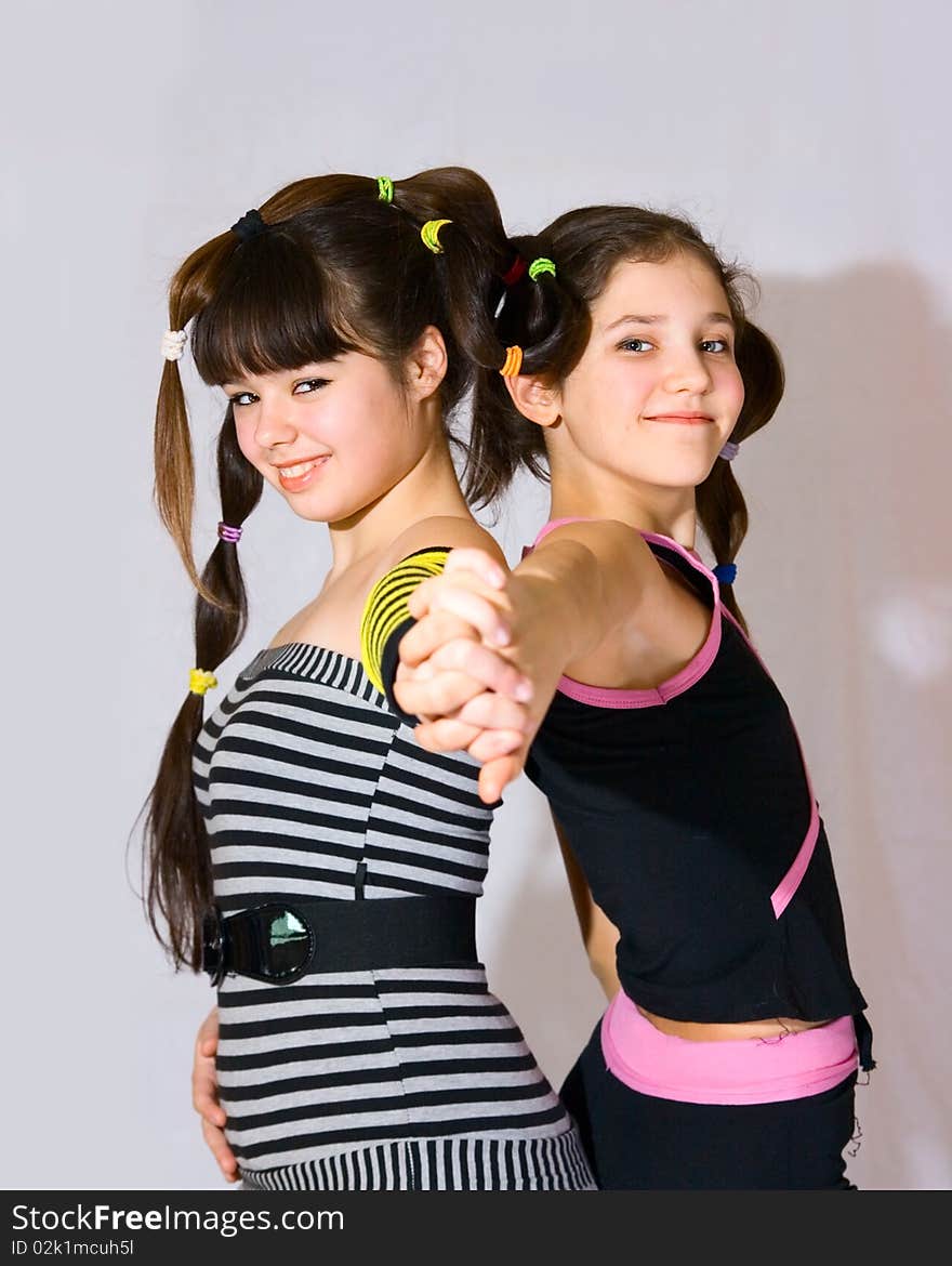 Two fun teen girls on grey background