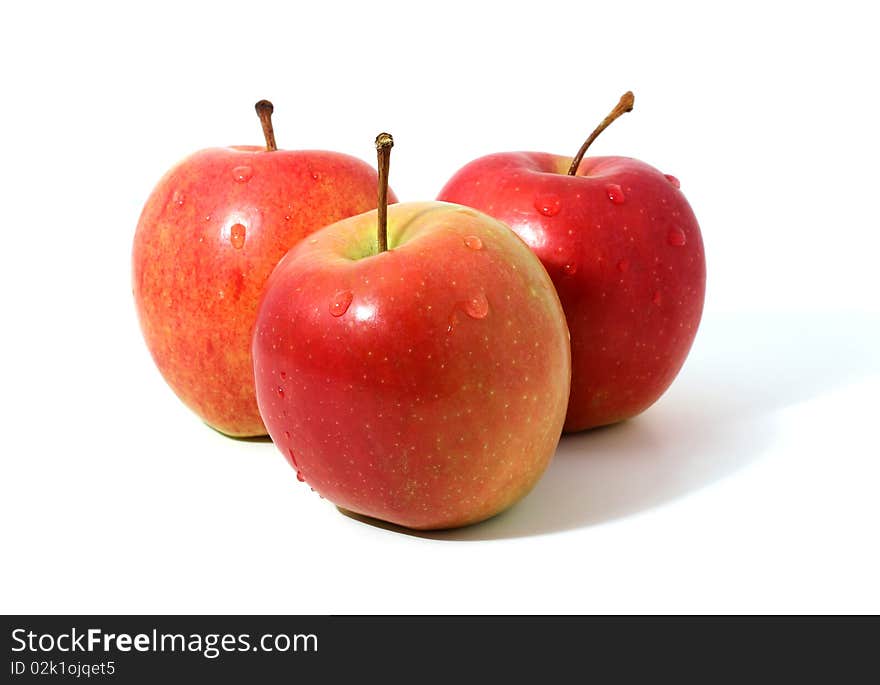 Three red apples with water drops isolated over white