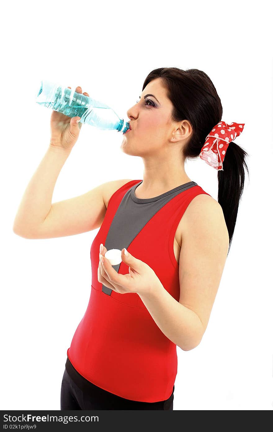 Young woman drinking water from plastic bottle after fitness isolated on white background