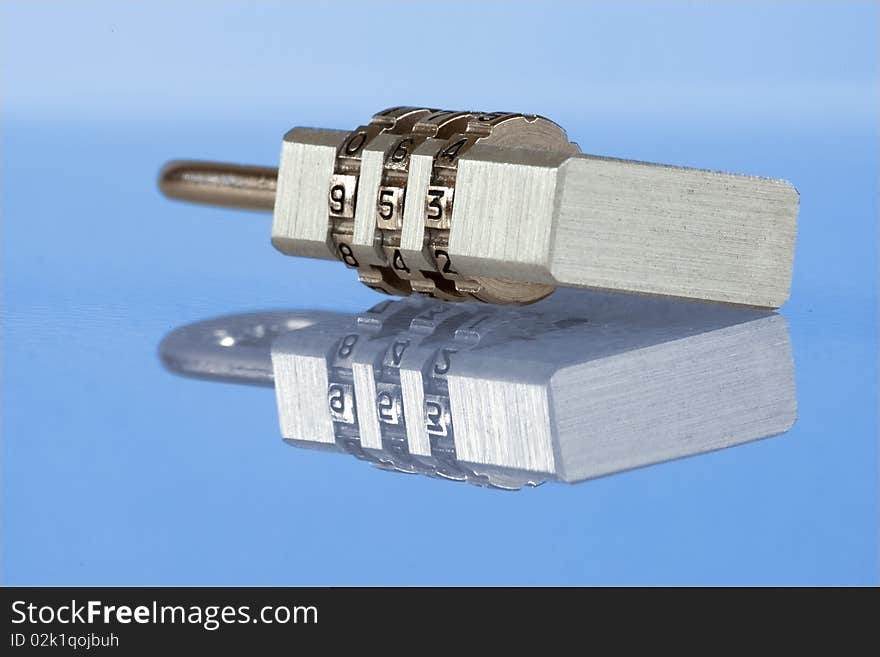 Numeric metal lock with reflection - detailed, close-up view on blue background. Numeric metal lock with reflection - detailed, close-up view on blue background