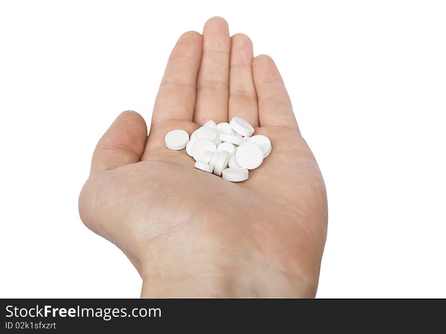 Pile of the white pills on the doctor`s palm isolated on white background