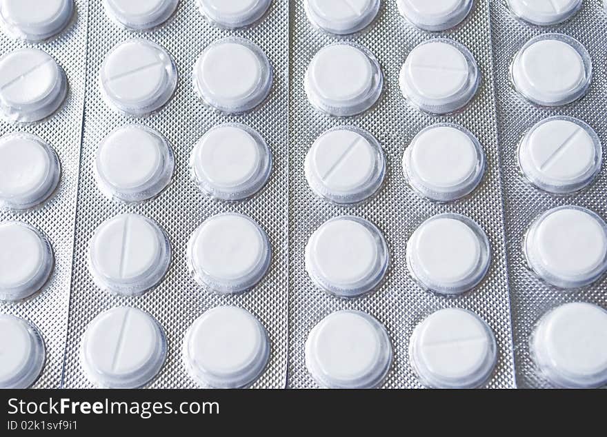 White tablets packed in tin blisters