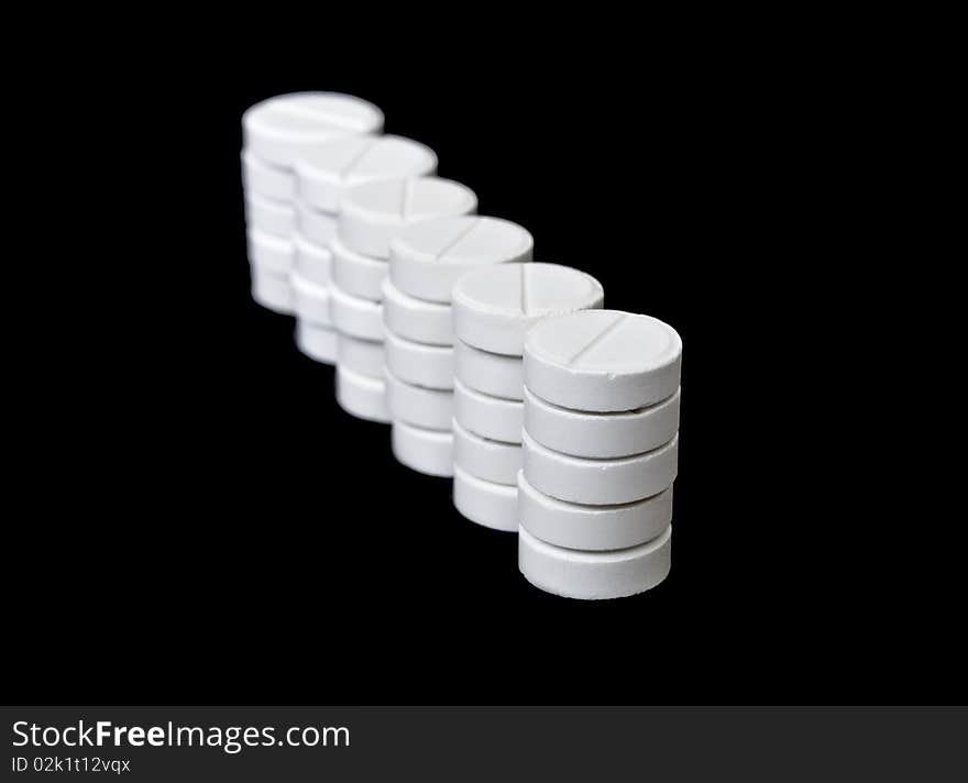 Columns of white pills isolated on black background