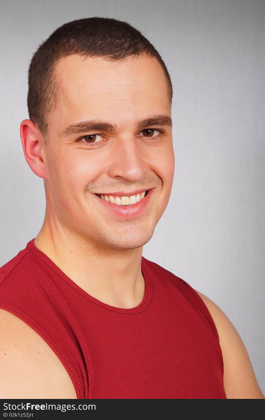 Portrait of smiling young man in the red undershirt. Portrait of smiling young man in the red undershirt.