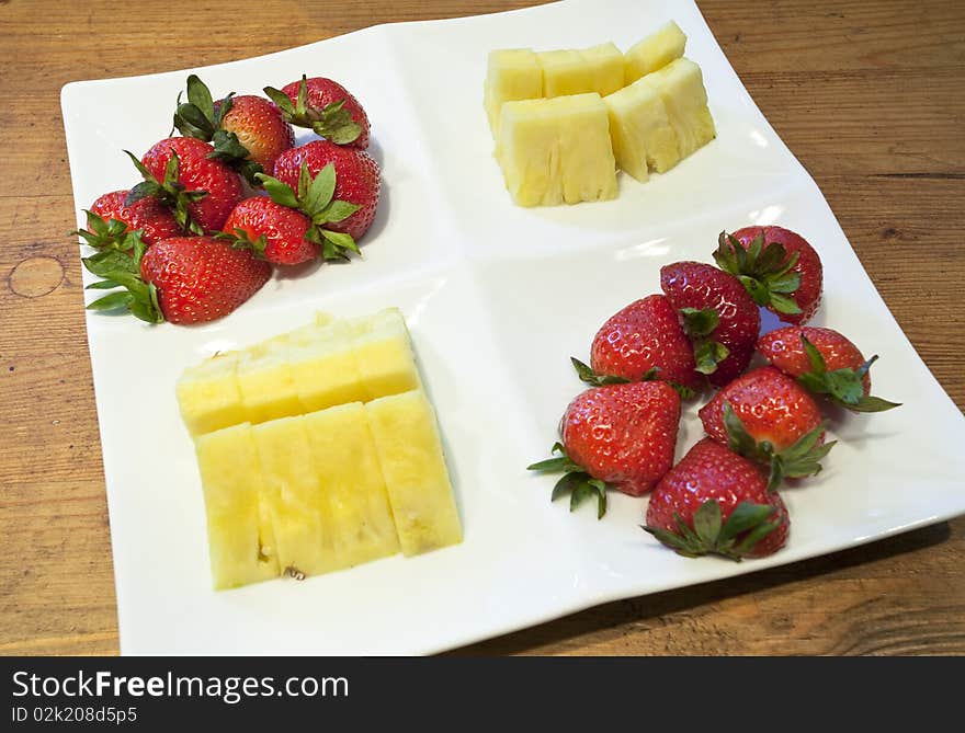 A fruit platter consisting of freshly cut pineapple and strawberries. A fruit platter consisting of freshly cut pineapple and strawberries.