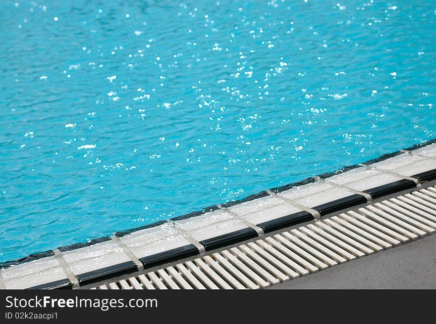 The edge of a luxury hotel swimming pool with copy space