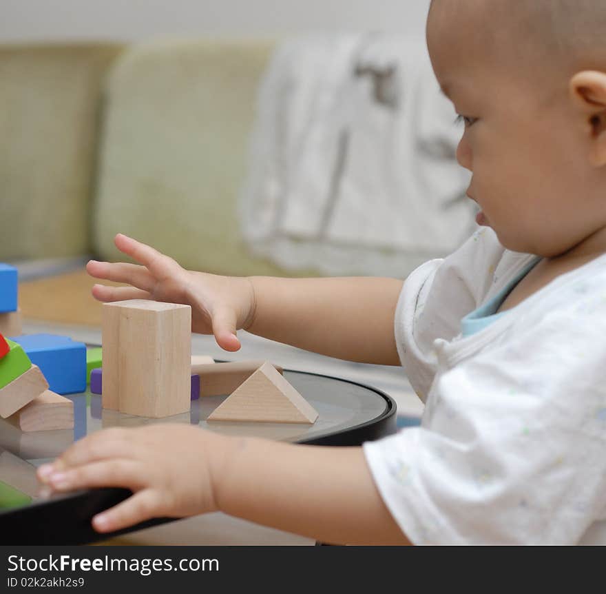 A child is playing with wooden toy blocks.