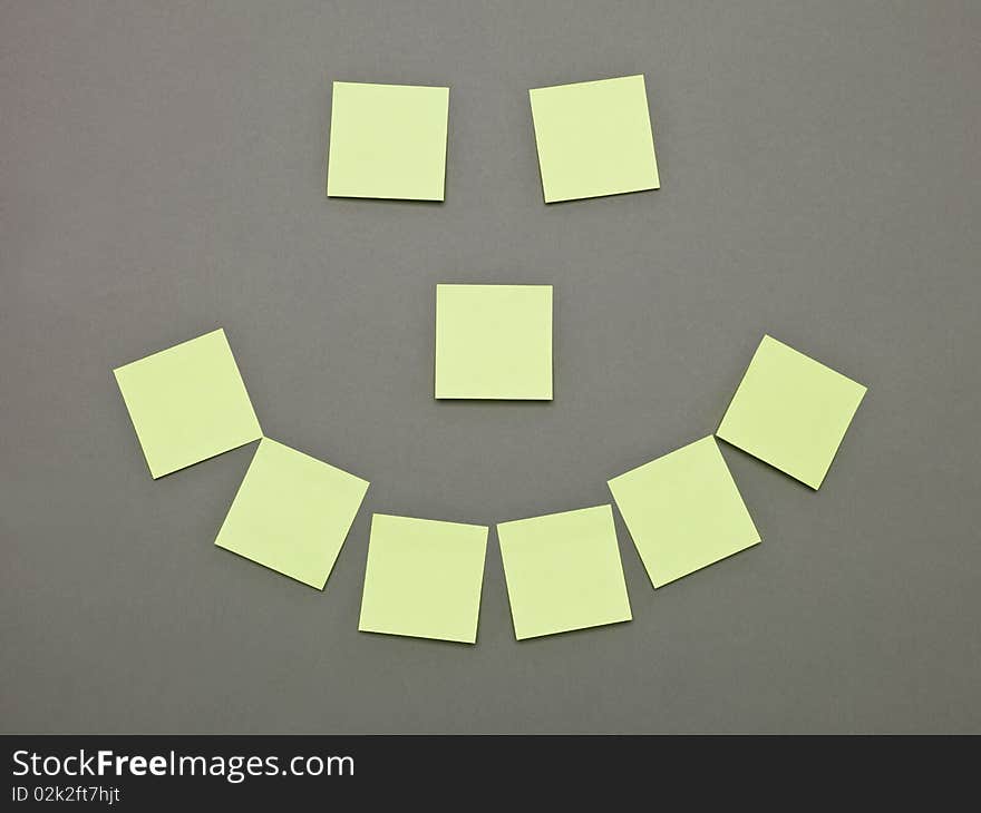 Mouth, nose and Eyes made of Yellow Adhesive Notes on grey background. Mouth, nose and Eyes made of Yellow Adhesive Notes on grey background