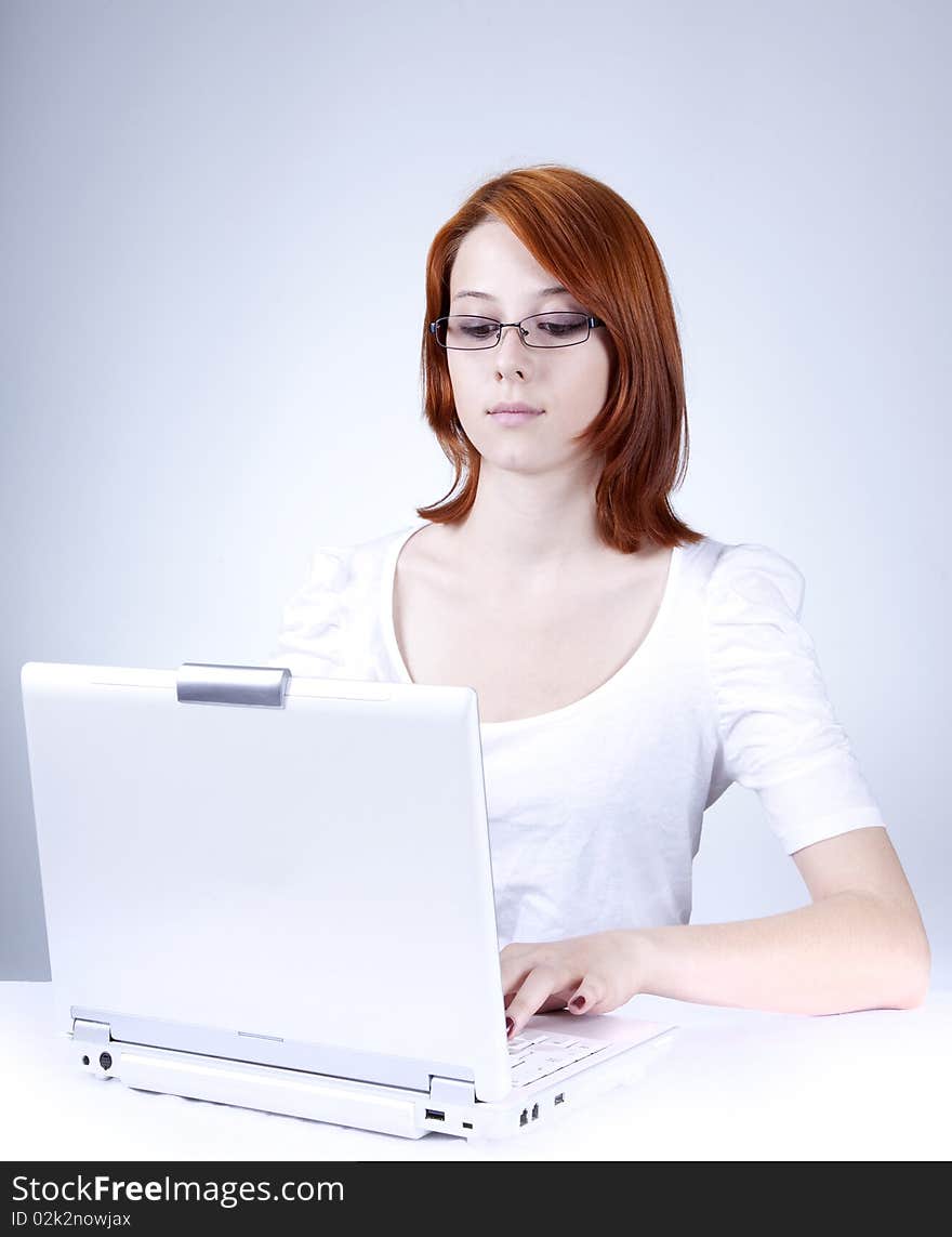 Red-haired girl with white notebook. Studio shot.