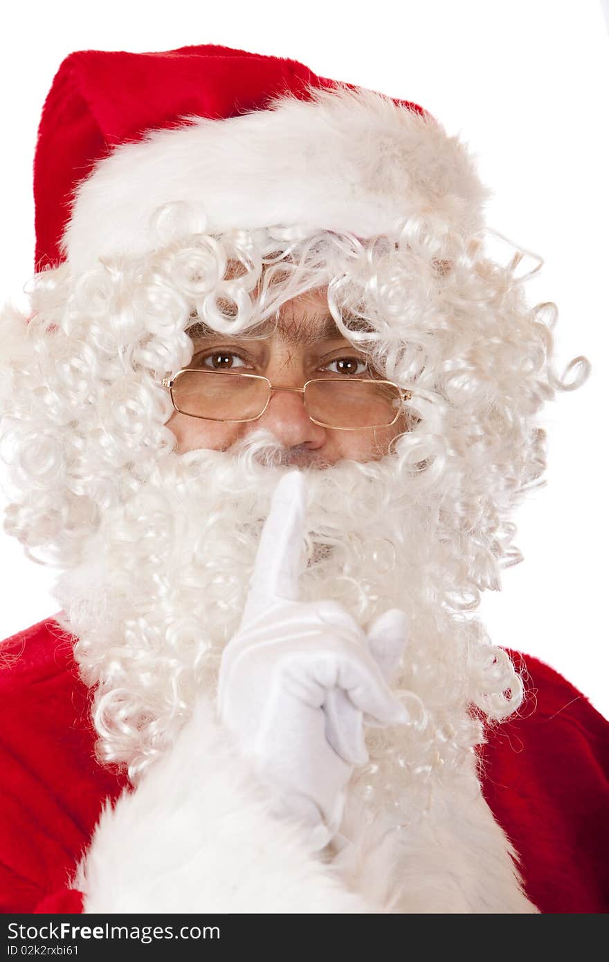 Happy Santa Claus puts finger on lips for silence