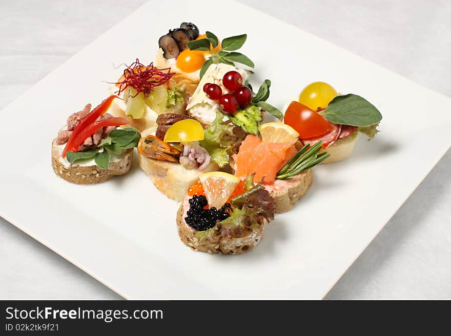 White plate with eight pieces of canapes. White plate with eight pieces of canapes