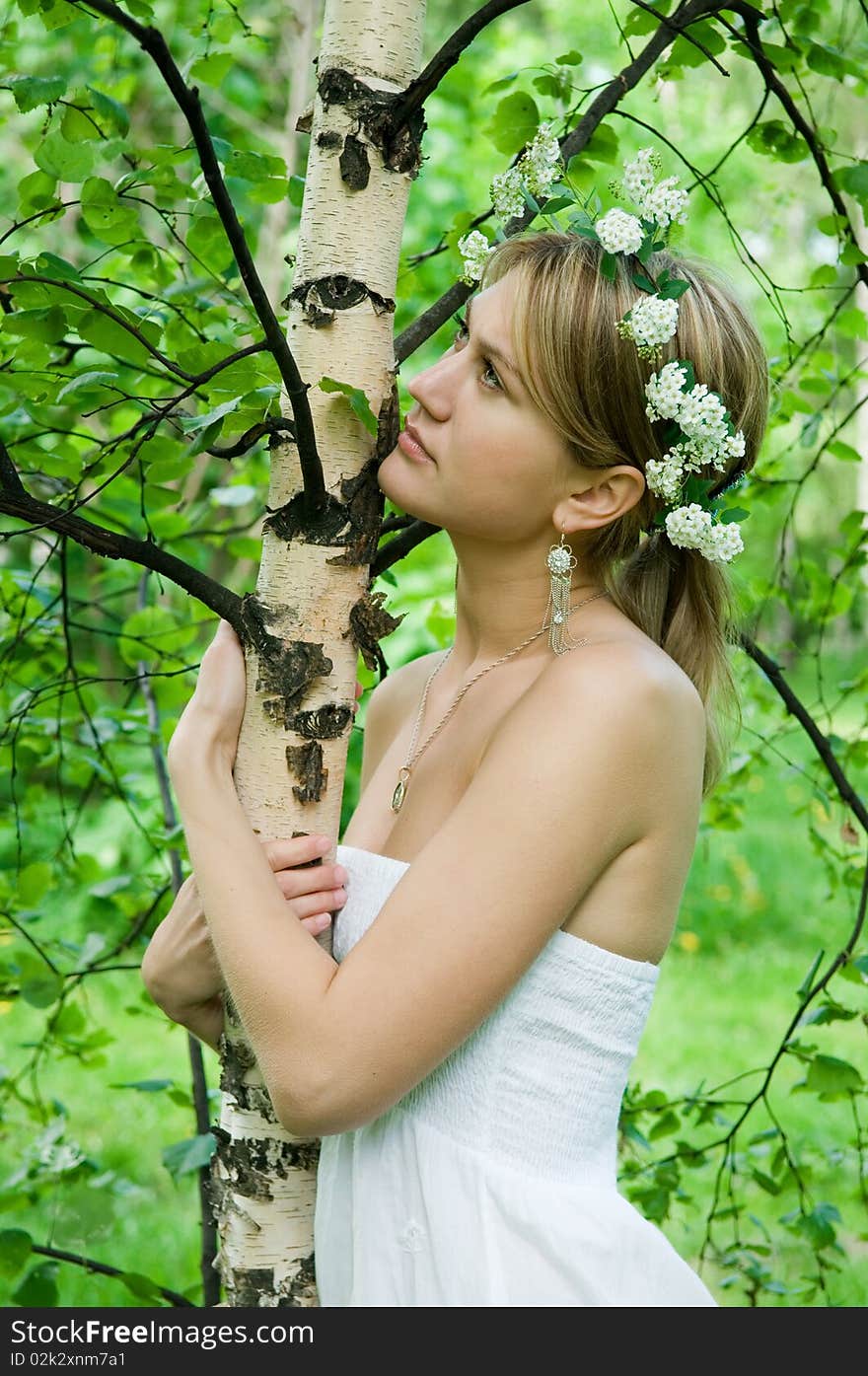 Young woman embraces   birch