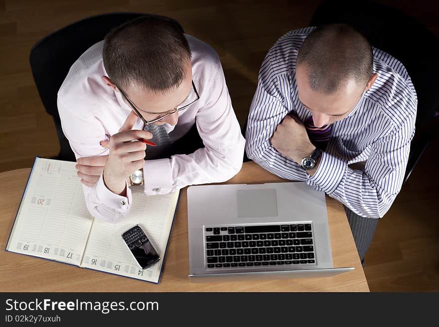 Two businessmen working at laptop. Two businessmen working at laptop