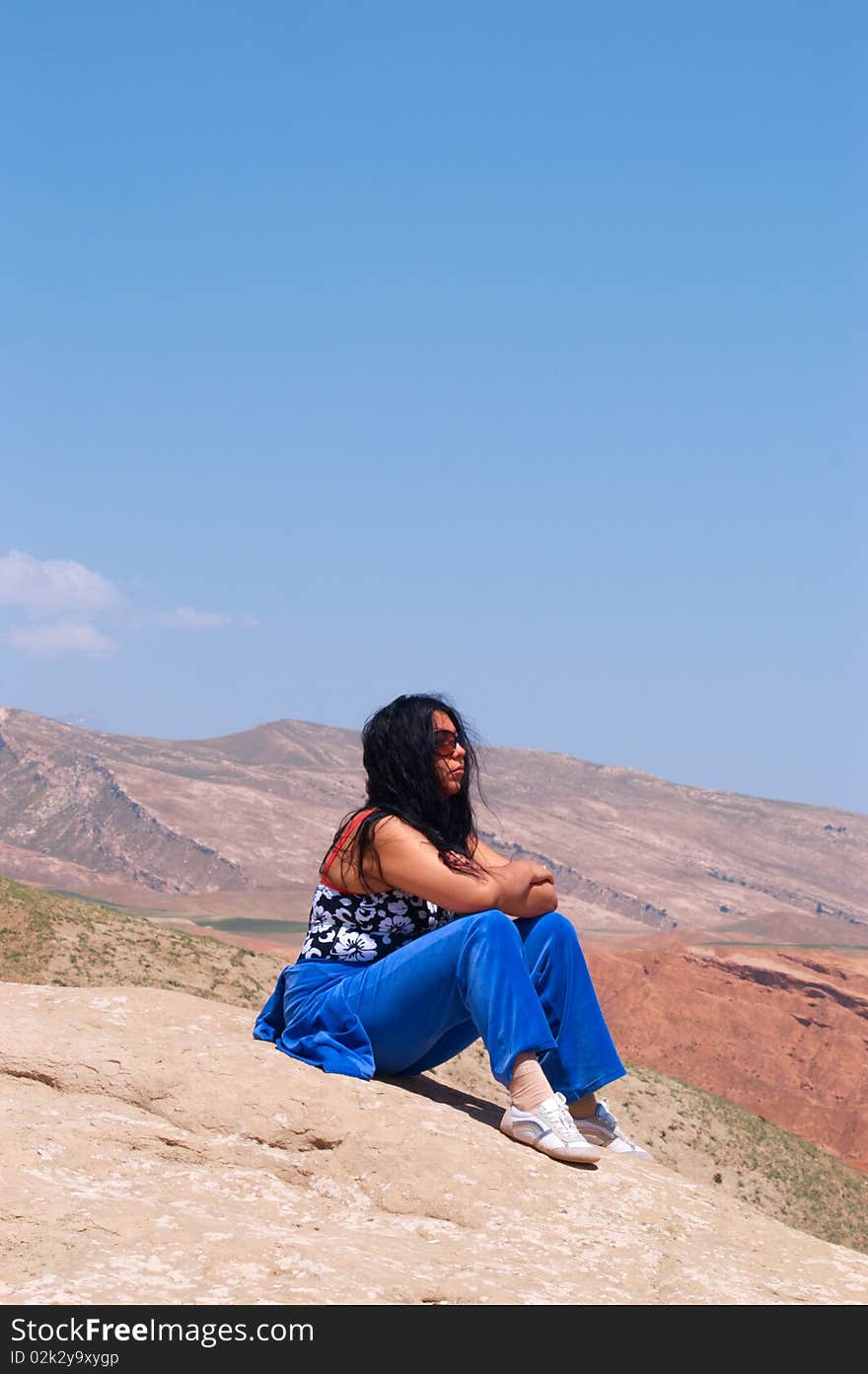 Sitting girl in mountains, Uzbekistan