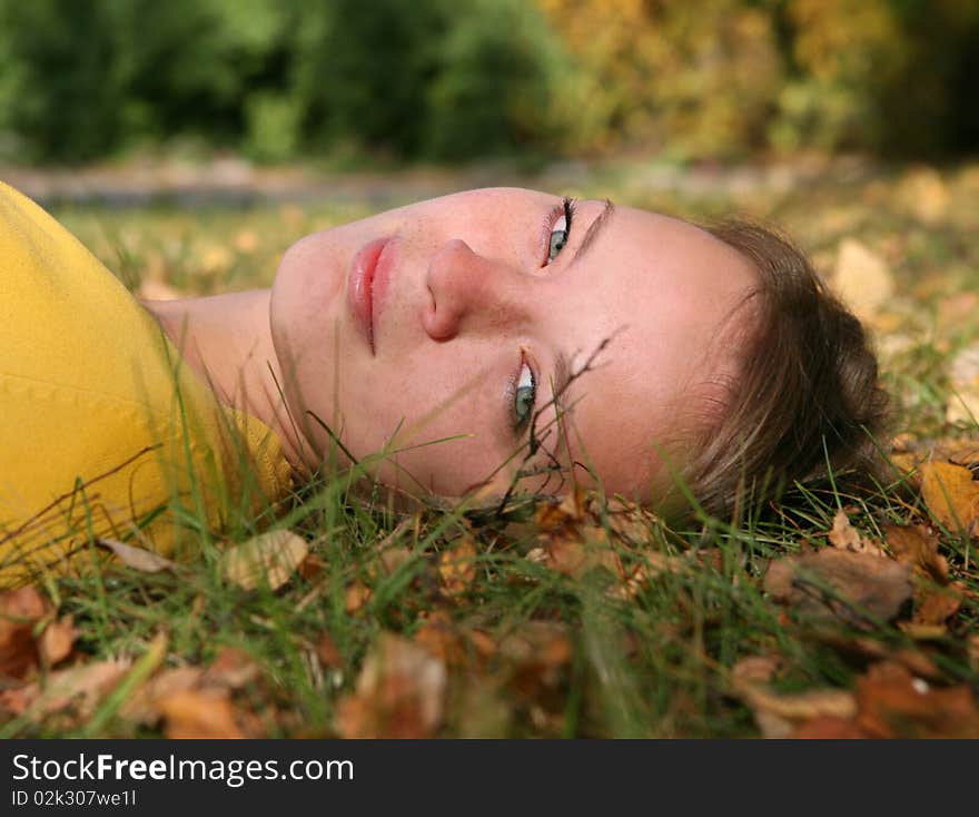 The smiling girl lays on a grass. outdoor