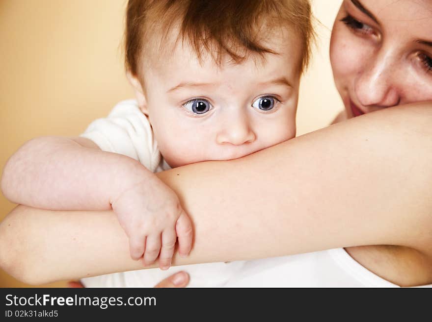 Baby boy in mothers arm looking with surprise; shallow DOF, focus on baby's eyes. Baby boy in mothers arm looking with surprise; shallow DOF, focus on baby's eyes