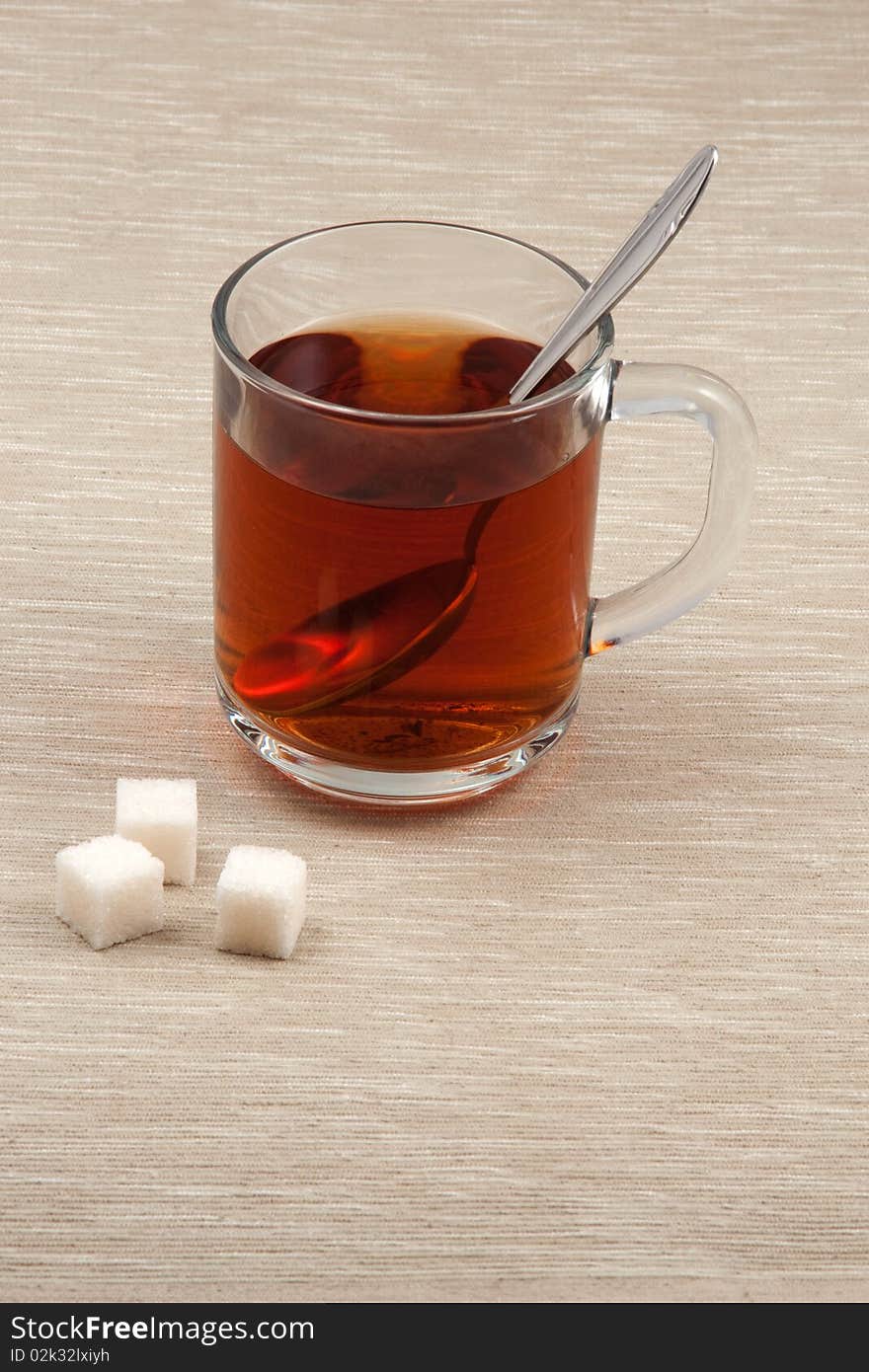 Glass cup of tea with spoon and sugar